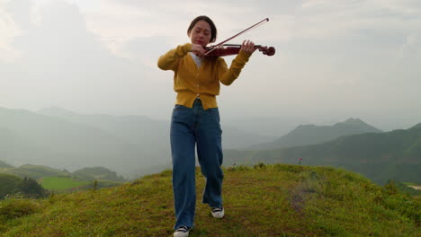 Pacífica-Violinista-En-La-Cima-De-Una-Montaña-Con-El-Viento-En-El-Pelo