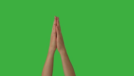 mujer con las manos unidas sobre un fondo verde