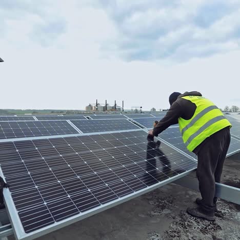 workers attach photovoltaic panel. construction of innovative solar energy farm on a flat roof of a huge building. sustainable energy.