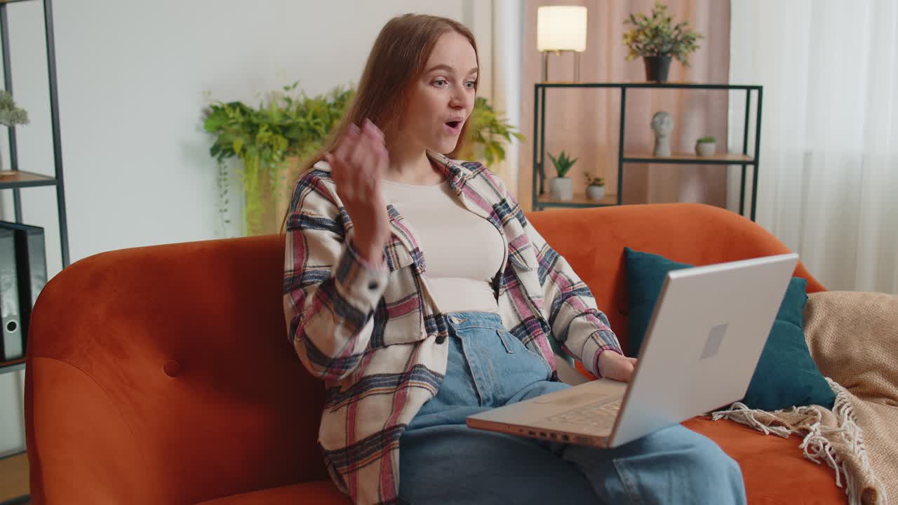Mladá dospělá žena v domácí kanceláři používá notebook, píše, prohlíží si stránky, říká wow, ano, zjistila skvělou velkou výhru