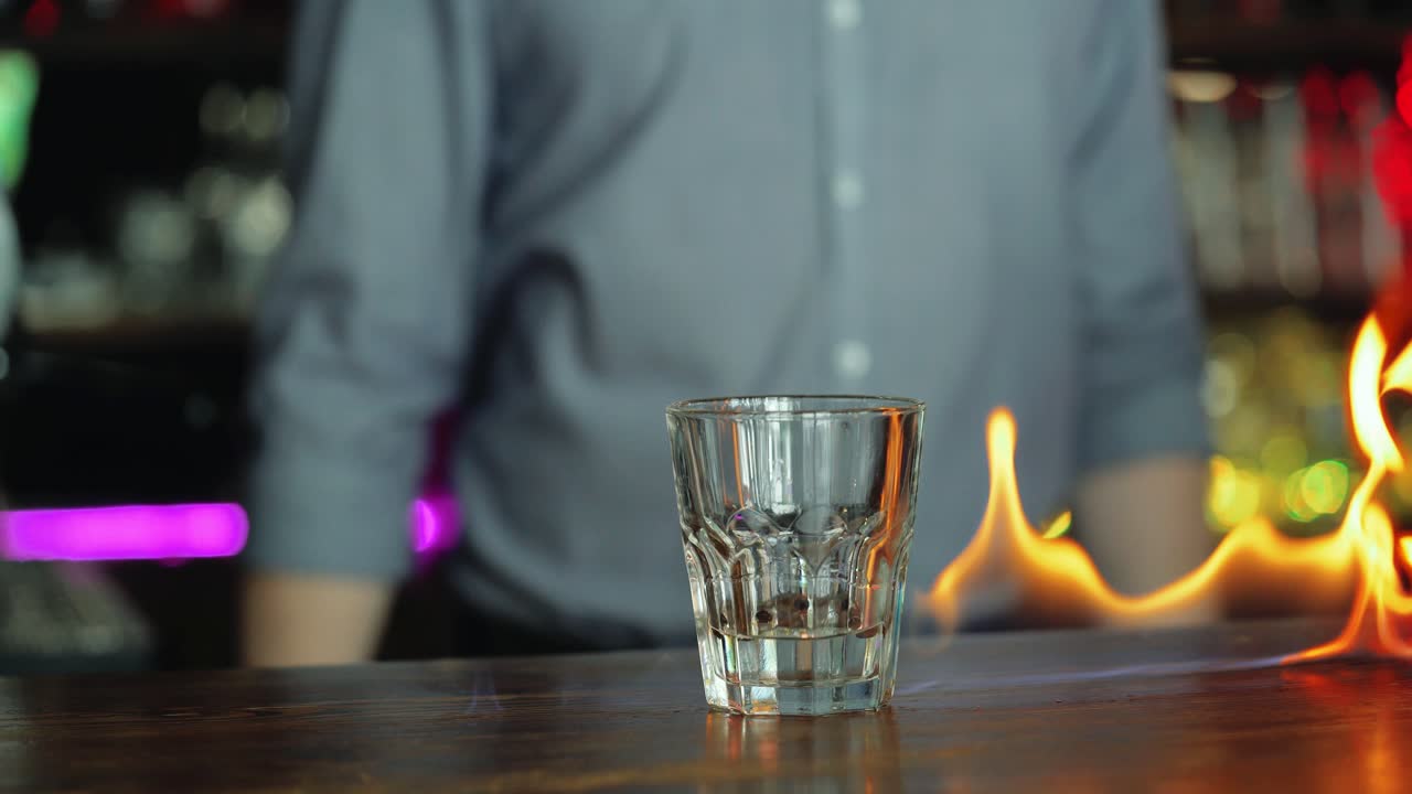 Young bartender making cool cocktail on fire.