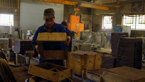 trabajador masculino que arregla el bloque de molde de madera en el taller 4k