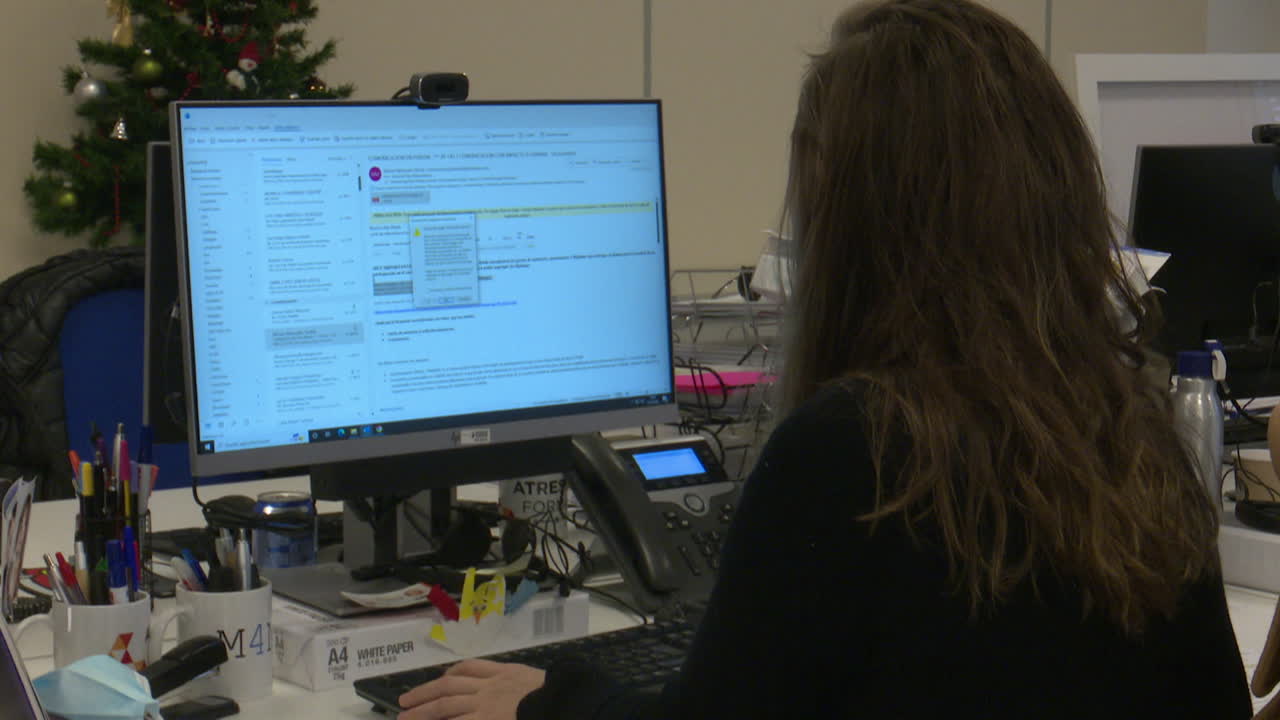 Woman working at a computer in an office setting.