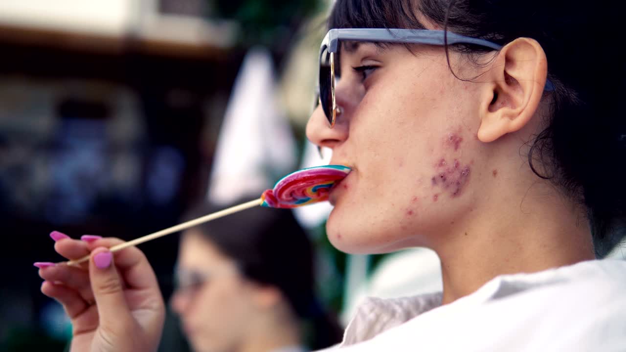 Beautiful teen girl licking lollipop and enjoying and dancing on the music