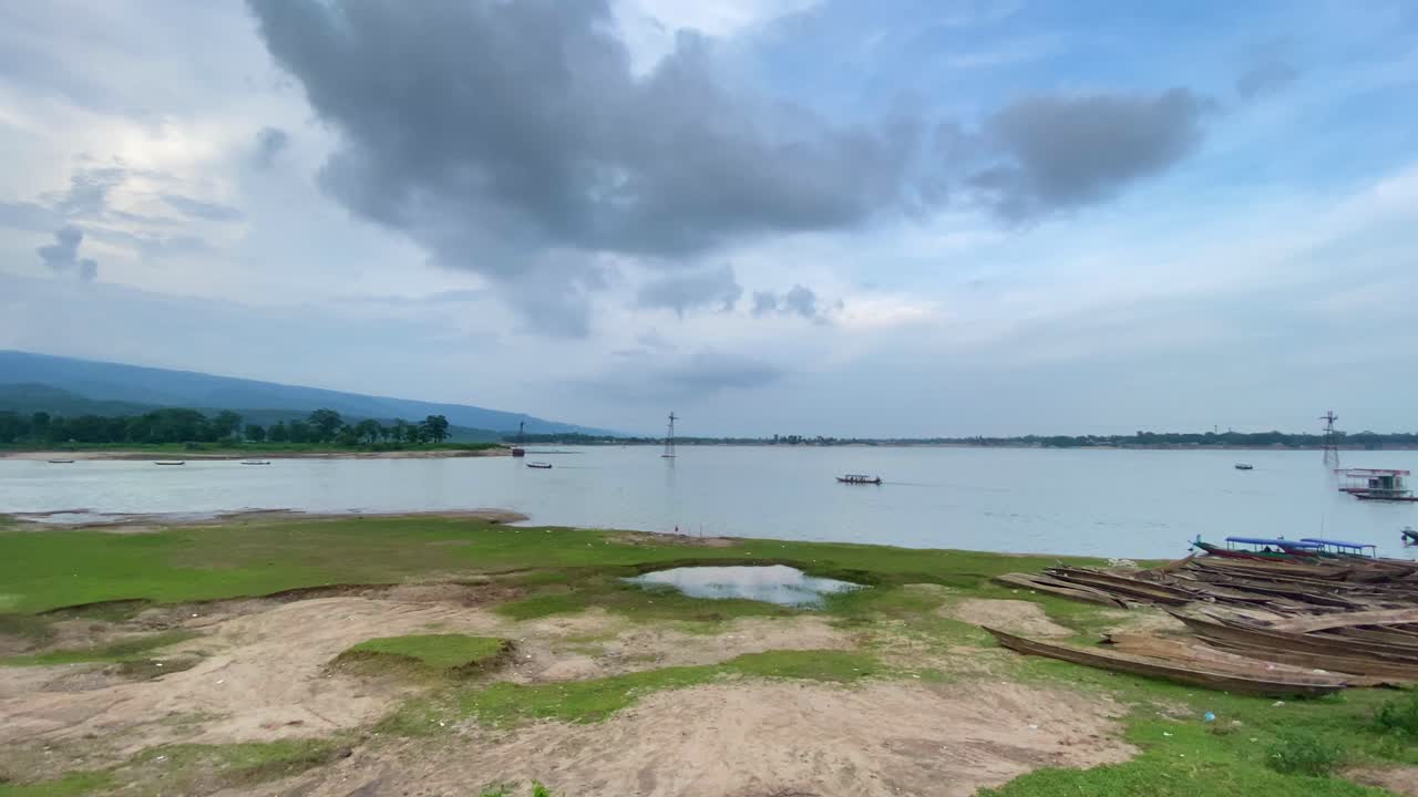 Paesaggio lacustre rurale con barche di legno e montagne in Bangladesh, vista panoramica
