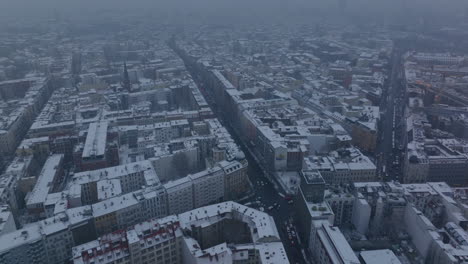 Vista-De-ángulo-Alto-De-Calles-Y-Edificios-En-La-Ciudad-De-Invierno-Cubierta-De-Nieve.-Vista-Panorámica-Aérea-Nebulosa.-Berlín,-Alemania