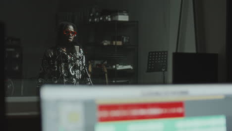 black musician in headphones singing into microphone in recording booth