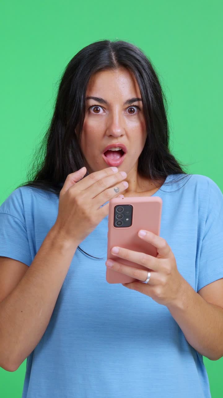 Shocked woman reading surprised news on smartphone