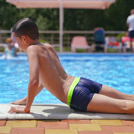 boy jumping into water. happy boy enjoying time in the swimming pool in summer daytime. joyful childhood in the water of the pool.