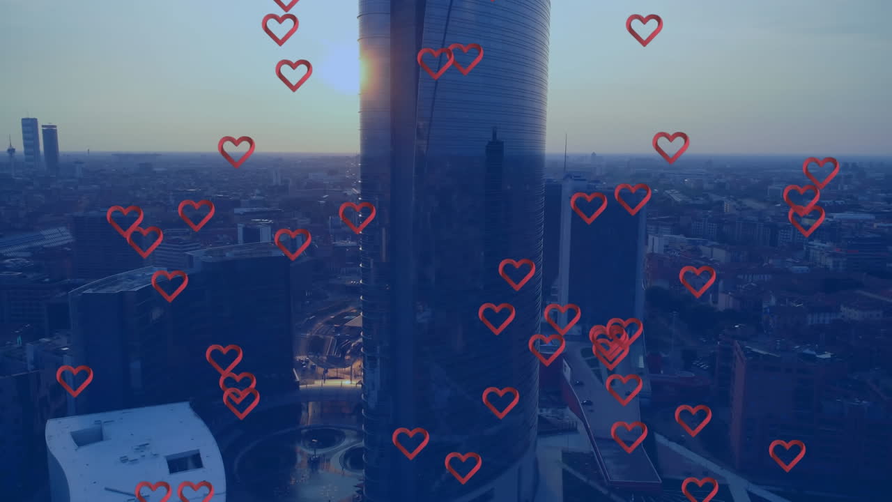 Animation of multiple red heart icons floating against aerial view of cityscape