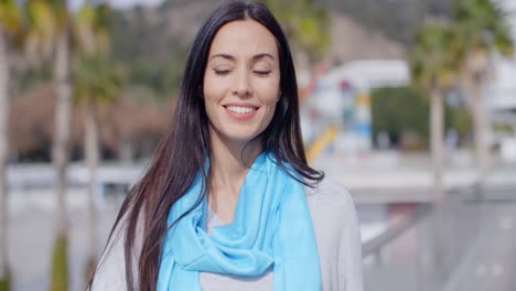 Smiling-vivacious-young-woman-in-an-urban-street