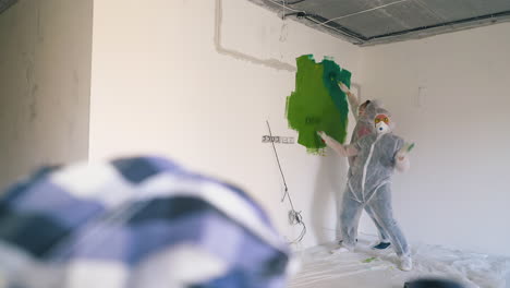 couple in transparent coveralls runs waving hands to paint
