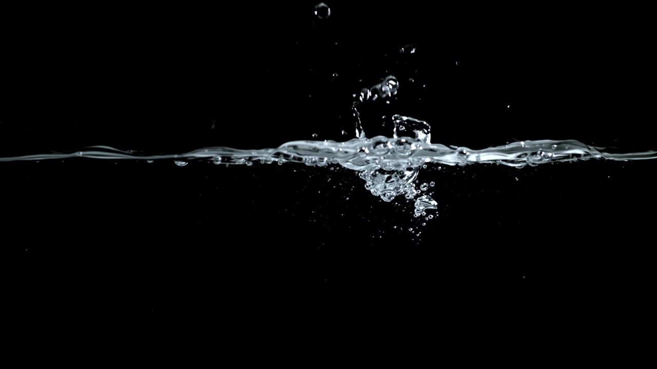 Clear Water Splashing with Bubbles Against Black Background