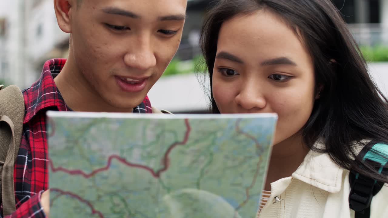 Handheld view of tourists with map choosing the best footpath