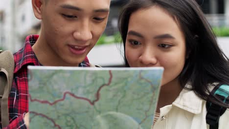 handheld view of tourists with map choosing the best footpath