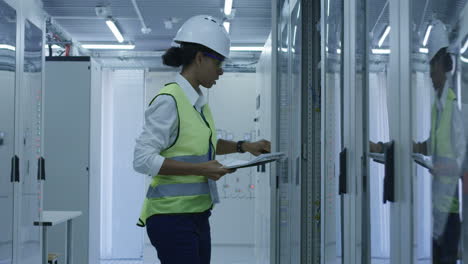 technician checking electrical panels in server room