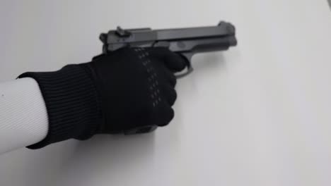 Person-with-a-black-glove-picks-up-a-loaded-firearm