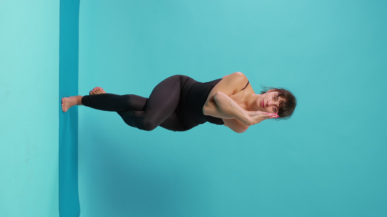 Vídeo vertical: mulher em forma fazendo exercícios de equilíbrio após atividade de treino