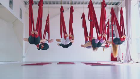 grupo de mujeres flexibles se relaja después de un entrenamiento de yoga anti-gravedad