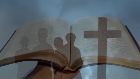 animation of peoples silhouettes and cross over bible and storm