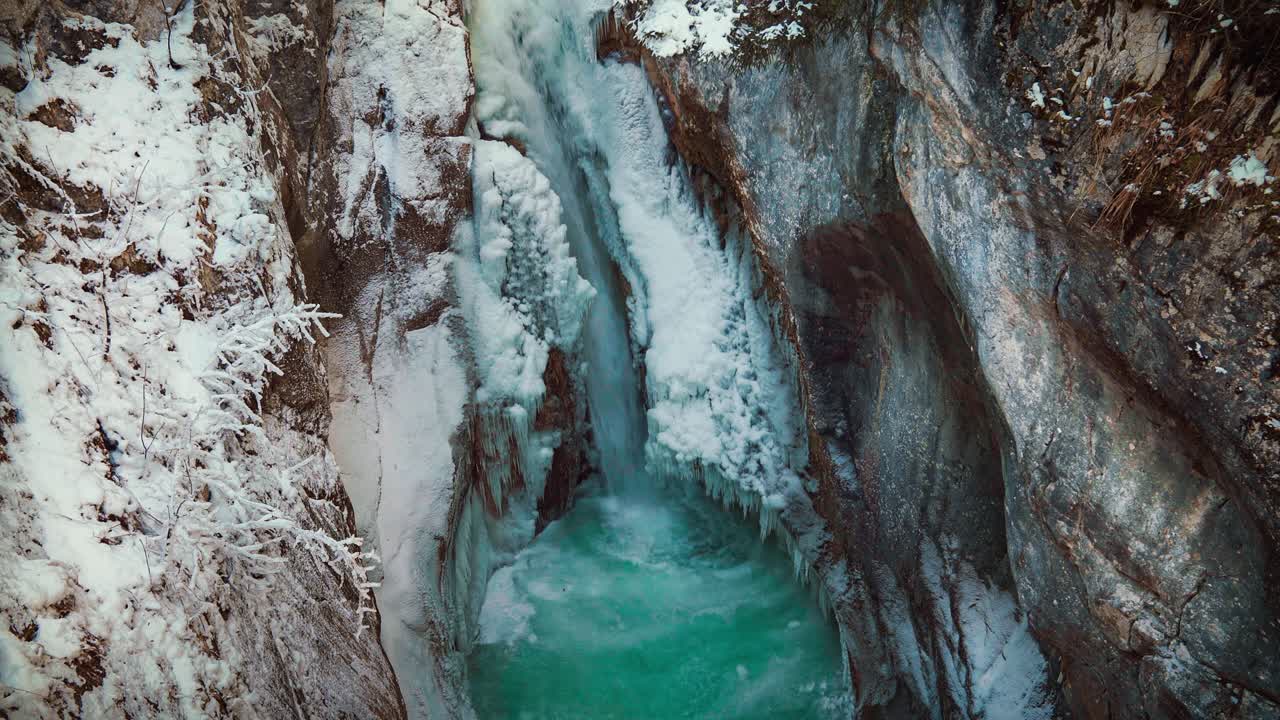 cinemagraph es un circuito de video sin fisuras de la famosa cascada de tatzelwurm y el cañón del río en los alpes bávaros en invierno en alemania. el agua está corriendo a través de rocas formadas naturalmente con nieve y hielo.