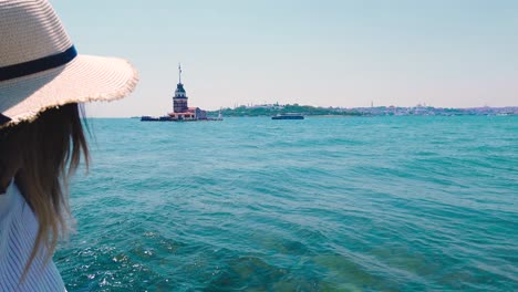 beautiful-girl-stands-in-front-of-Bosphorus-and-Maidens-Tower,a-popular-destination-in-Istanbul,Turkey