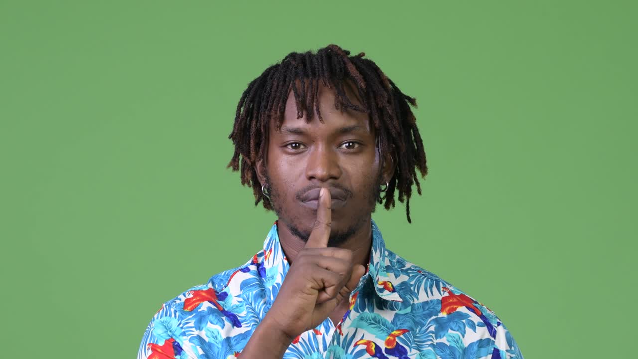 Young handsome African tourist man with finger on lips