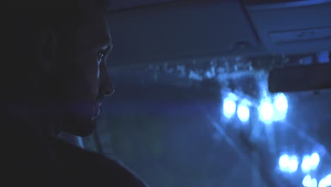 the man driving the car on the night rainy road