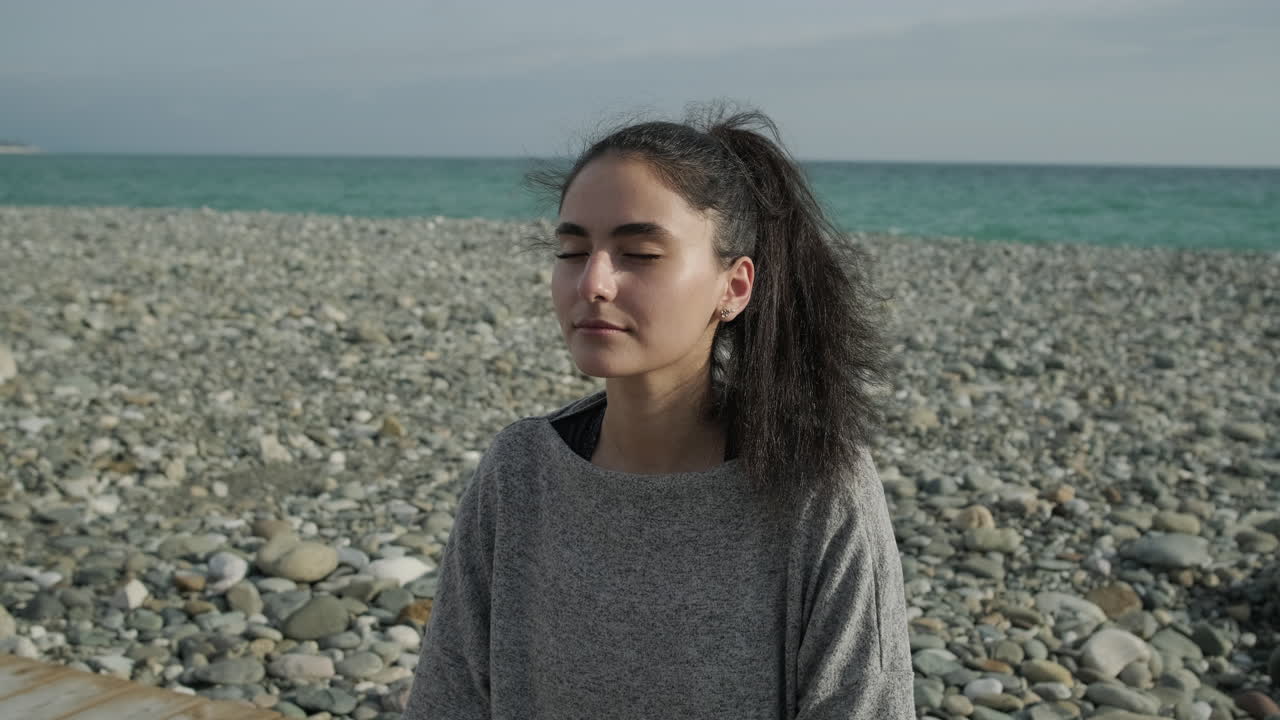 Žena medituje na pláži