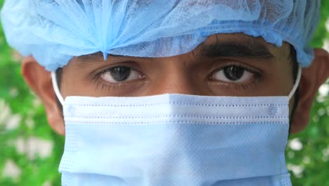 close-up of a man wearing a medical mask and surgical cap