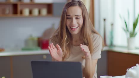 woman celebrating good news on laptop