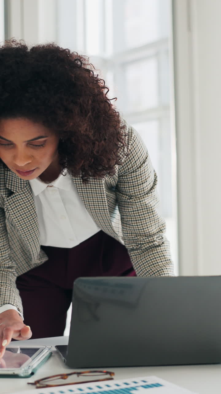 Professional Woman Working on Laptop and Tablet in Modern Office