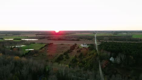 dramatic sunset with a pronounced red sun, then revealing a exclusive luxury house on the lake