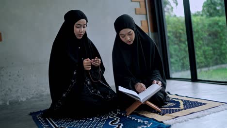 two young muslim woman praying in prayer room