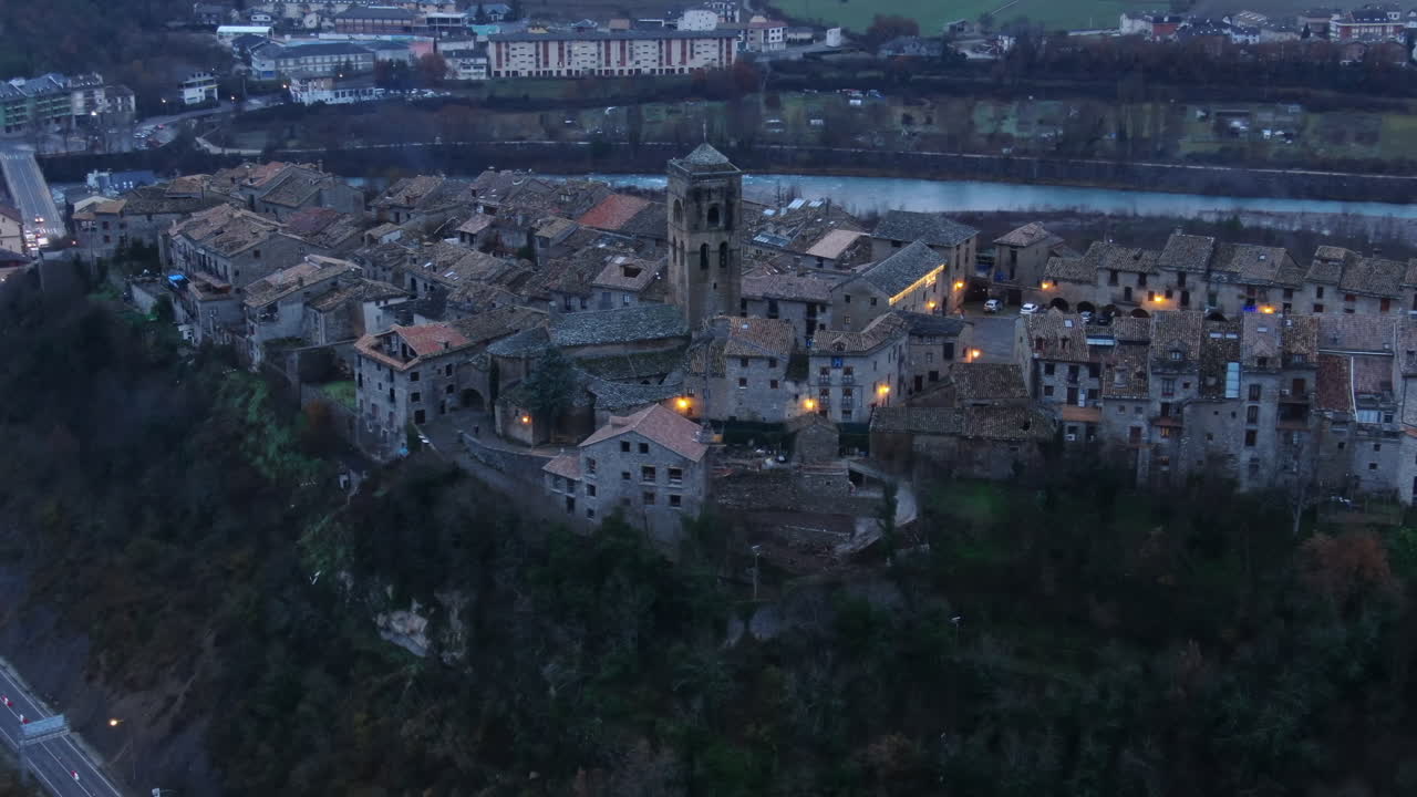 La pittoresca cittadina medievale di Aínsa sui Pirenei spagnoli con luci scintillanti al crepuscolo