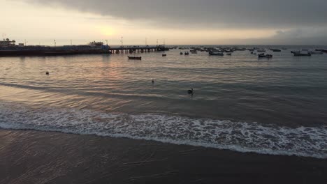 Video-De-Drones-De-La-Orilla-Del-Océano-Con-Botes-Y-Un-Muelle-En-La-Distancia