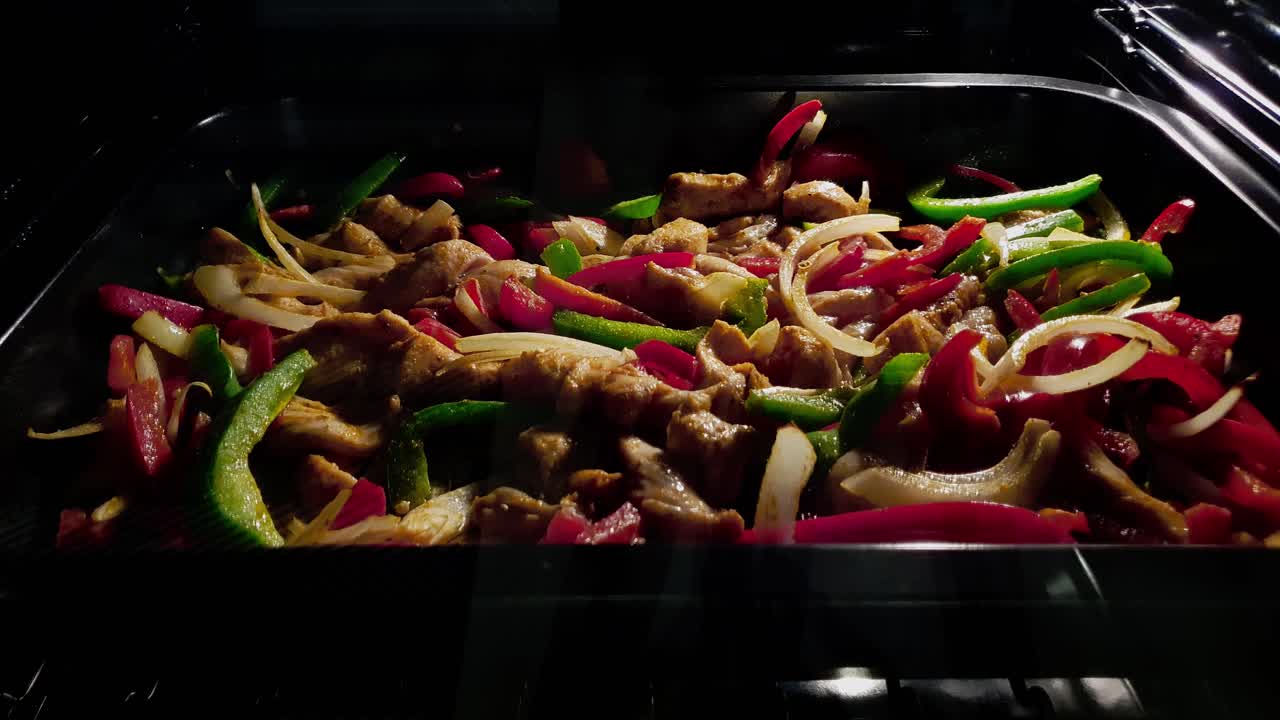 Close-up of chicken fajitas cooking in oven. Timelapse