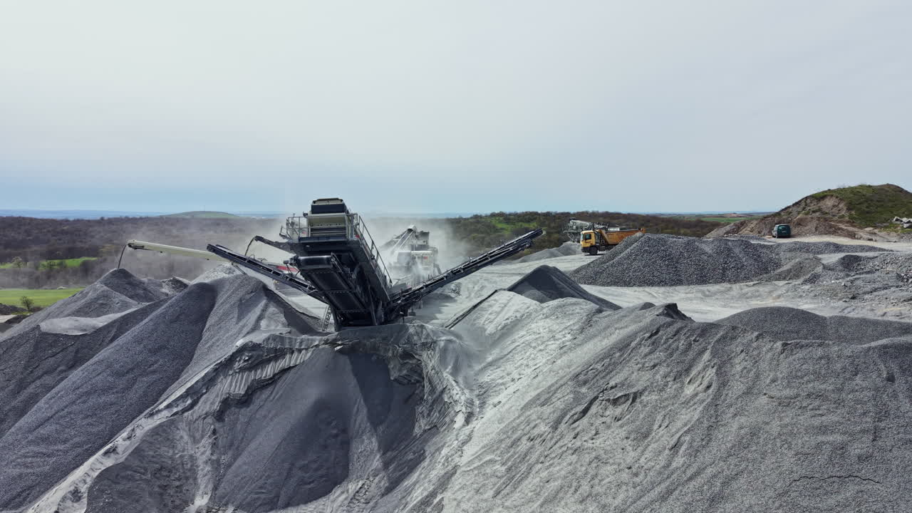 Granite quarry site with machinery and piles of stone during the day