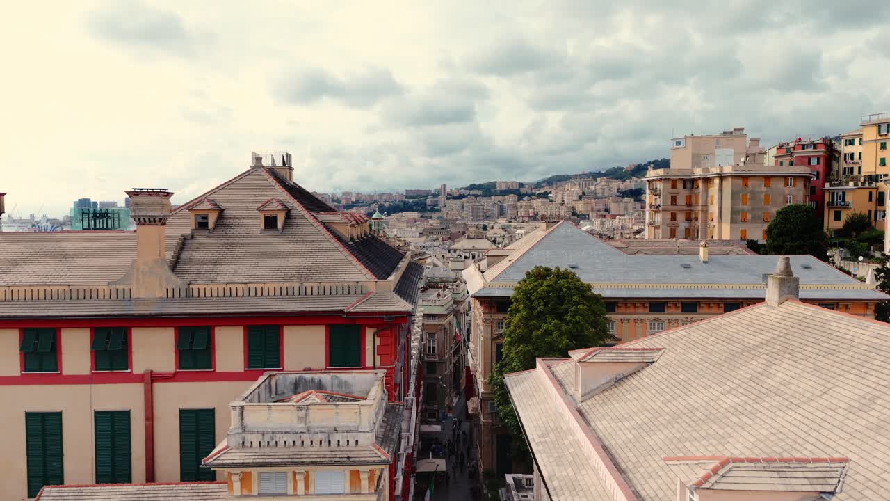 Genoa's historic city center with tourists walking through narrow streets at sunset, aerial view