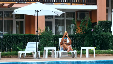 people sitting by the poolside of a resort swimming pool
