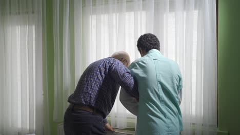 Aged-man-in-need-of-care-spends-time-with-his-lovely-and-respectful-grandson.