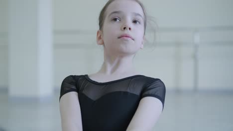 young ballerina practicing dance moves in studio