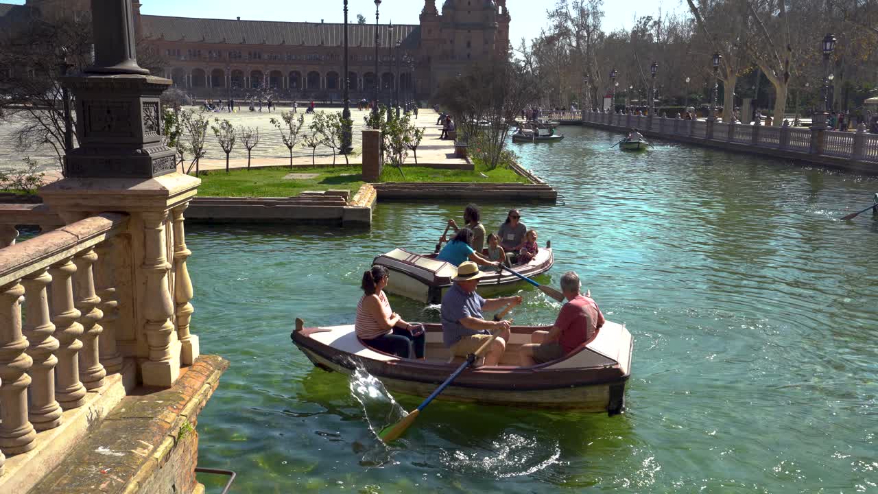 Tourists rowing boats in Plaza de España, Sevilla, a tourist destination in Andalucia stable shot panning left shot in 4k on gimbal