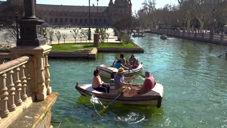 tourists rowing boats in plaza de españa, sevilla, a tourist destination in andalucia stable shot panning left shot in 4k on gimbal