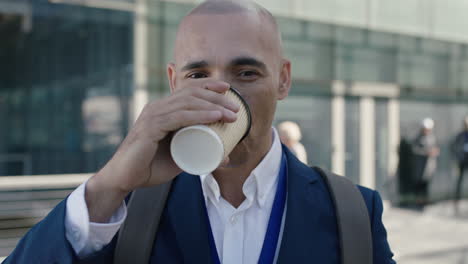 close-up-portrait-of-bald-hispanic-businessman-looking-at-camera-drinking-coffee-corporate-office