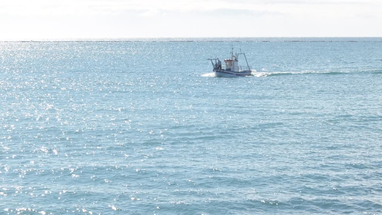 маленький рыбацкий корабль плывет в солнечное утро