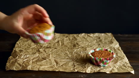 Chef-put-cupcakes-on-baking-paper.-Hand-lay-out-vanilla-cupcakes