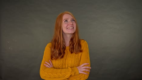 Smiling-redhead-woman-in-sweater-looking-up