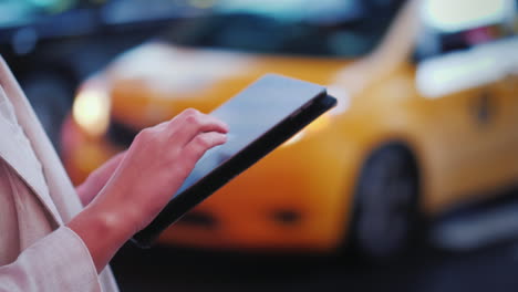 use la tableta en una calle concurrida en nueva york en el fondo pasando los famosos taxis amarillos cerca de u