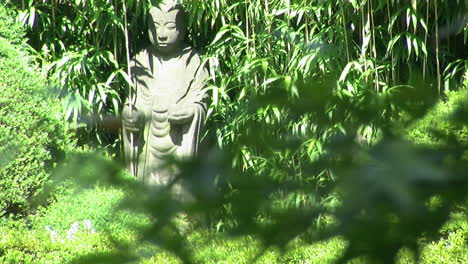 focus-pull from japanese maple leaves in foreground to buddhist statue of jizo in background